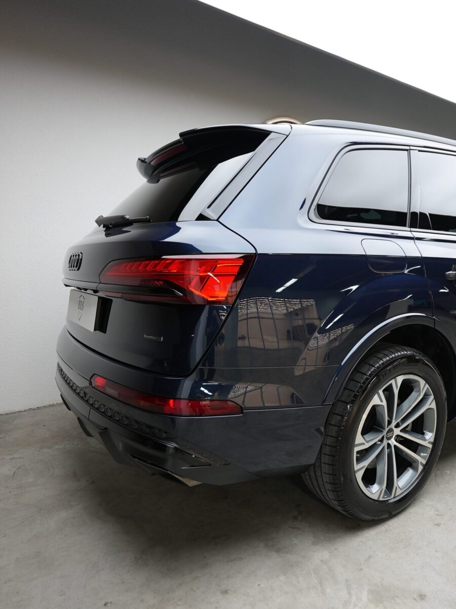 Stüdyoda arkadan geniş açıyla fotoğraflanmış lacivert Audi Q7