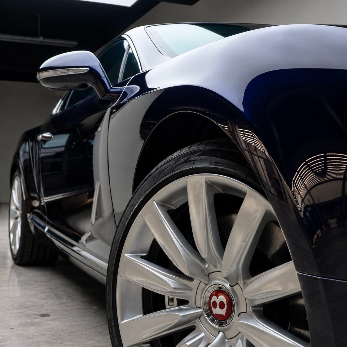 Lacivert Bentley yan ayna, çamurluk ve gümüş jant yakın plan